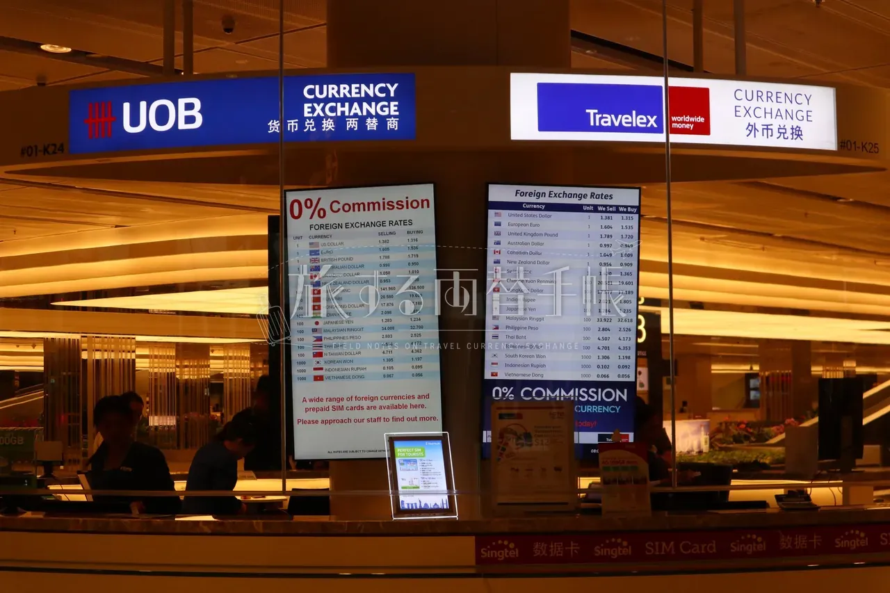 チャンギ空港の UOB と Travelex の両替カウンターが並ぶ様子。各社のレート表ディスプレイと「0% Commission」掲示