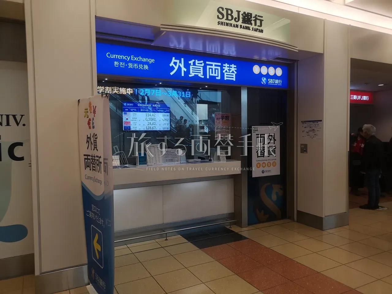 羽田空港の SBJ 銀行(新韓銀行 Japan)外貨両替カウンターと EXCHANGE RATES モニター・学割キャンペーン表示