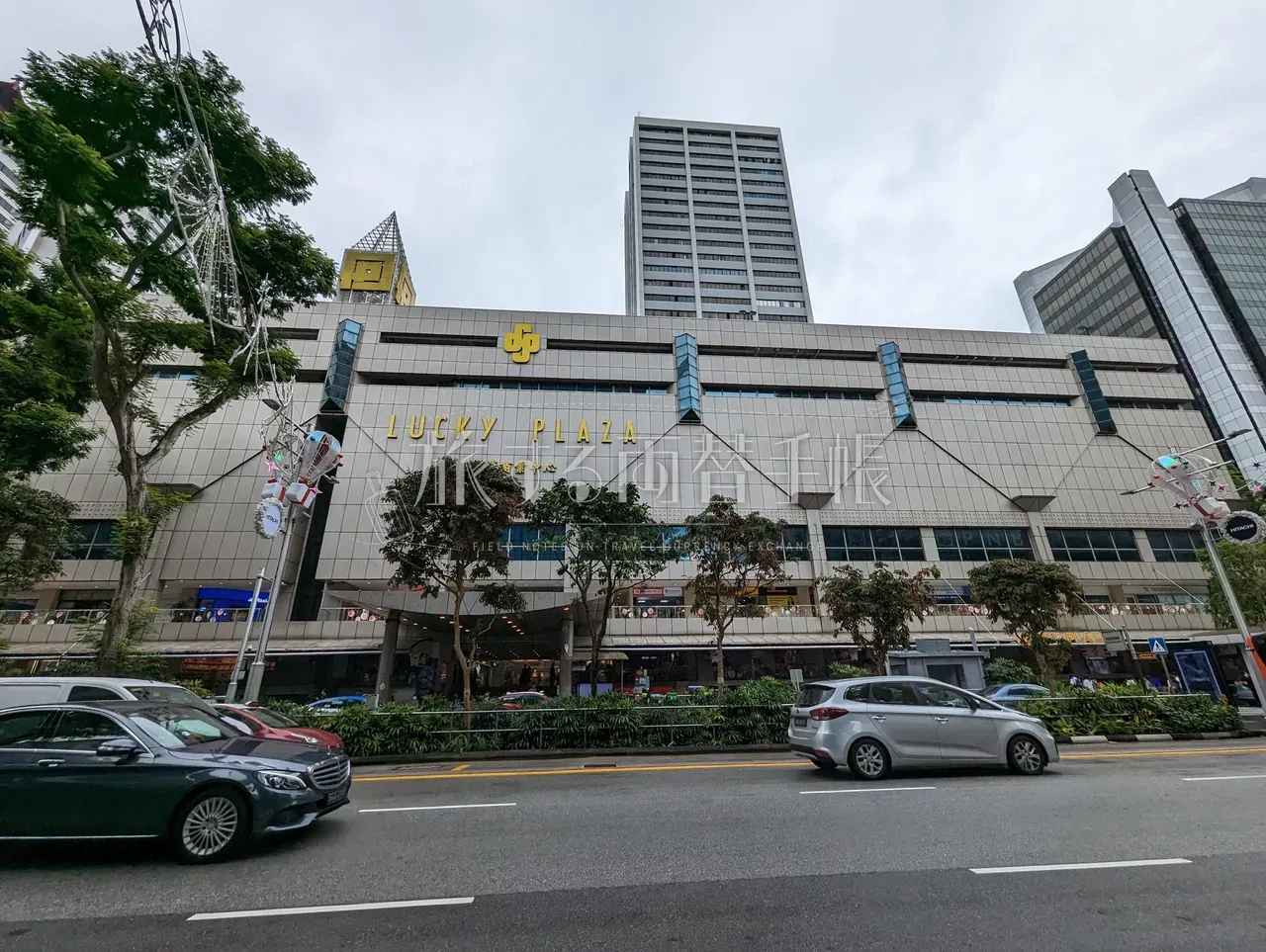 シンガポール・オーチャードの両替店集積ビル「LUCKY PLAZA」外観と街路の植栽