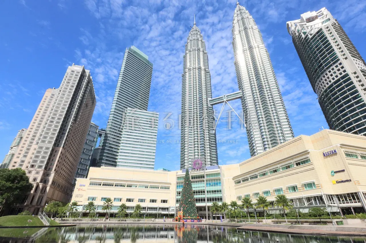 クアラルンプール KLCC 公園から見上げたペトロナス・ツインタワーと Suria KLCC モールの晴天構図