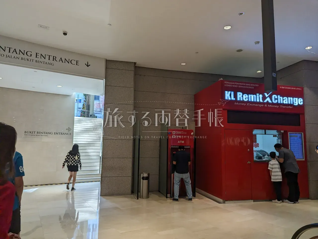 ブキッビンタン入口に面した赤い小屋型両替店 KL Remit Xchange と隣接する CIMB Bank ATM