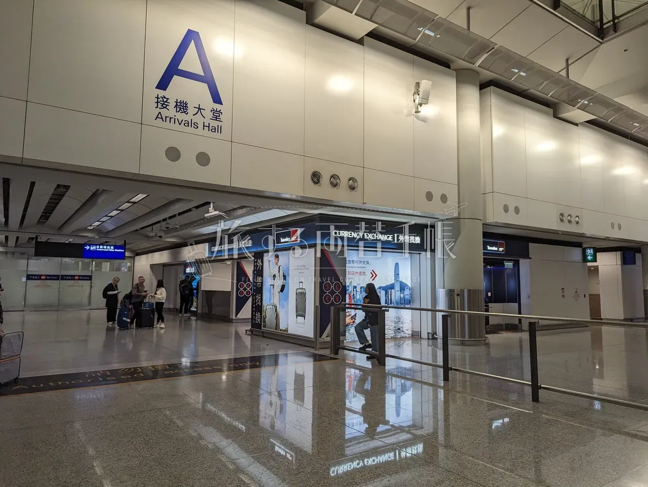 香港国際空港 到着ロビー A の Travelex 両替カウンターと到着客