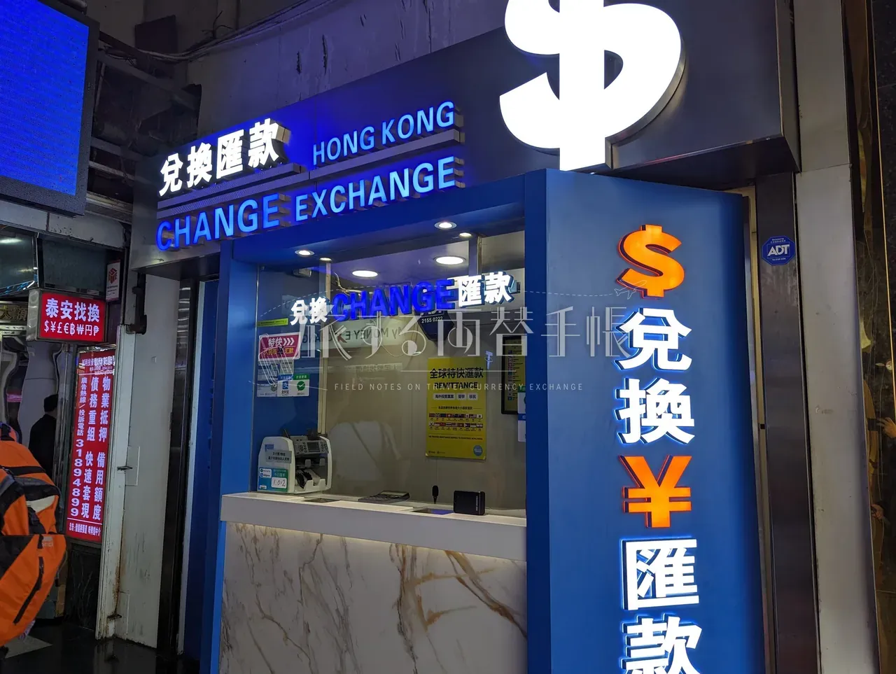 重慶大厦内 Hong Kong Change Exchange 系列の青看板と立体ドルサイン